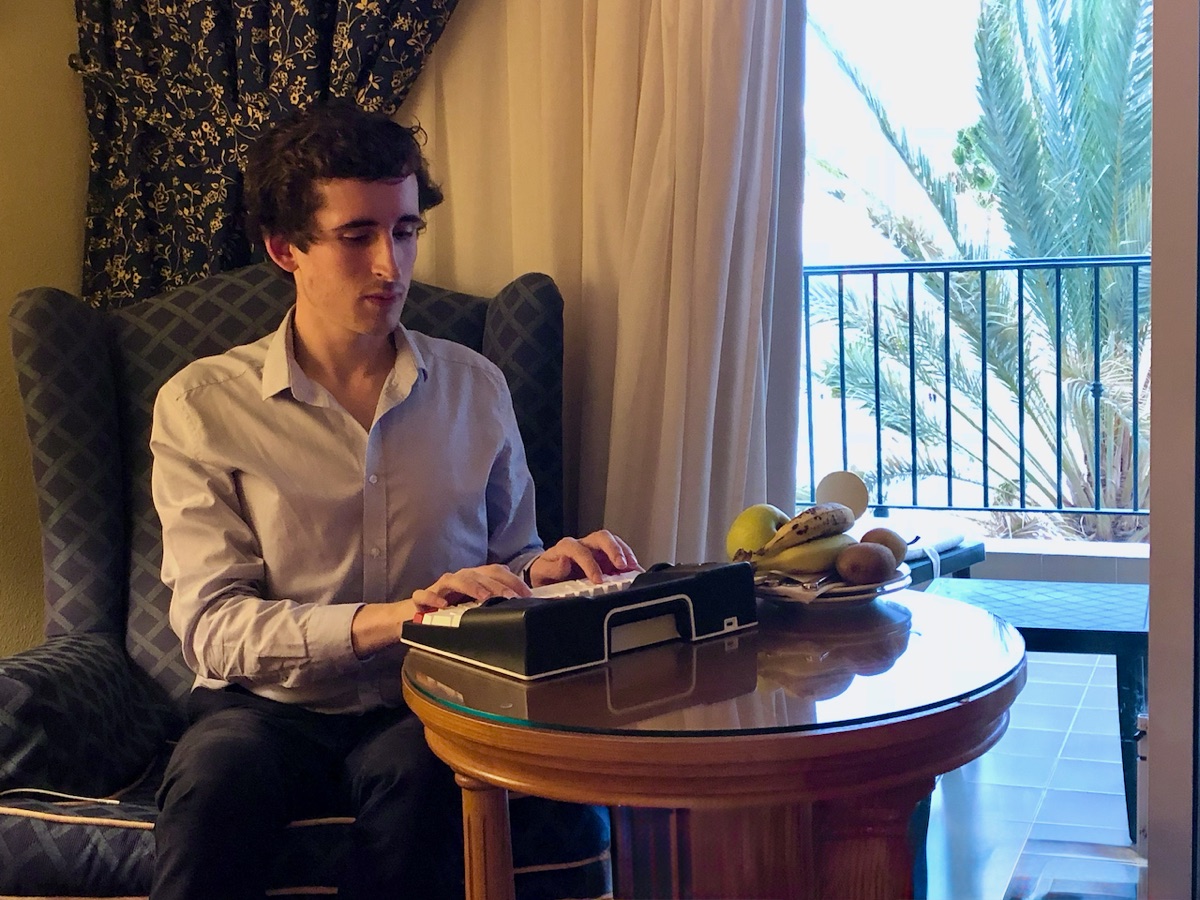 Pierre-Henry Soria jouant d'un petit clavier près d'une fenêtre
